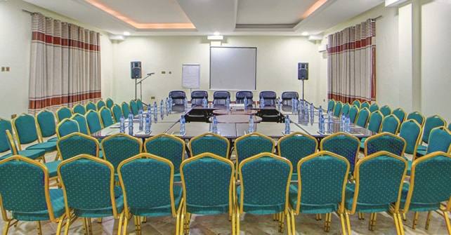 The conference hall prepared with microphones and water at each place