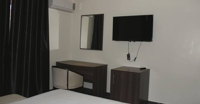 Deluxe Room desk and chair beneath a wall-mounted TV and mirror