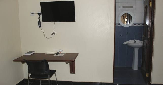Double Room writing desk and wall-mounted TV beside the shower room