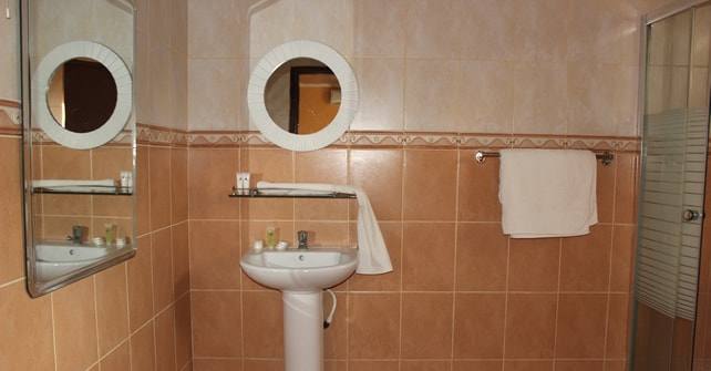 VIP Ensuite bathroom with round mirrors and warm tiles